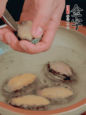鮑魚加鹽、清水浸泡，用勺子挖出鮑魚肉。