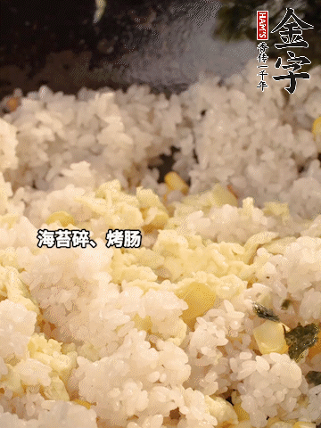剩米飯下鍋炒散，依次下玉米粒、雞蛋、烤腸、海苔碎翻炒均勻。