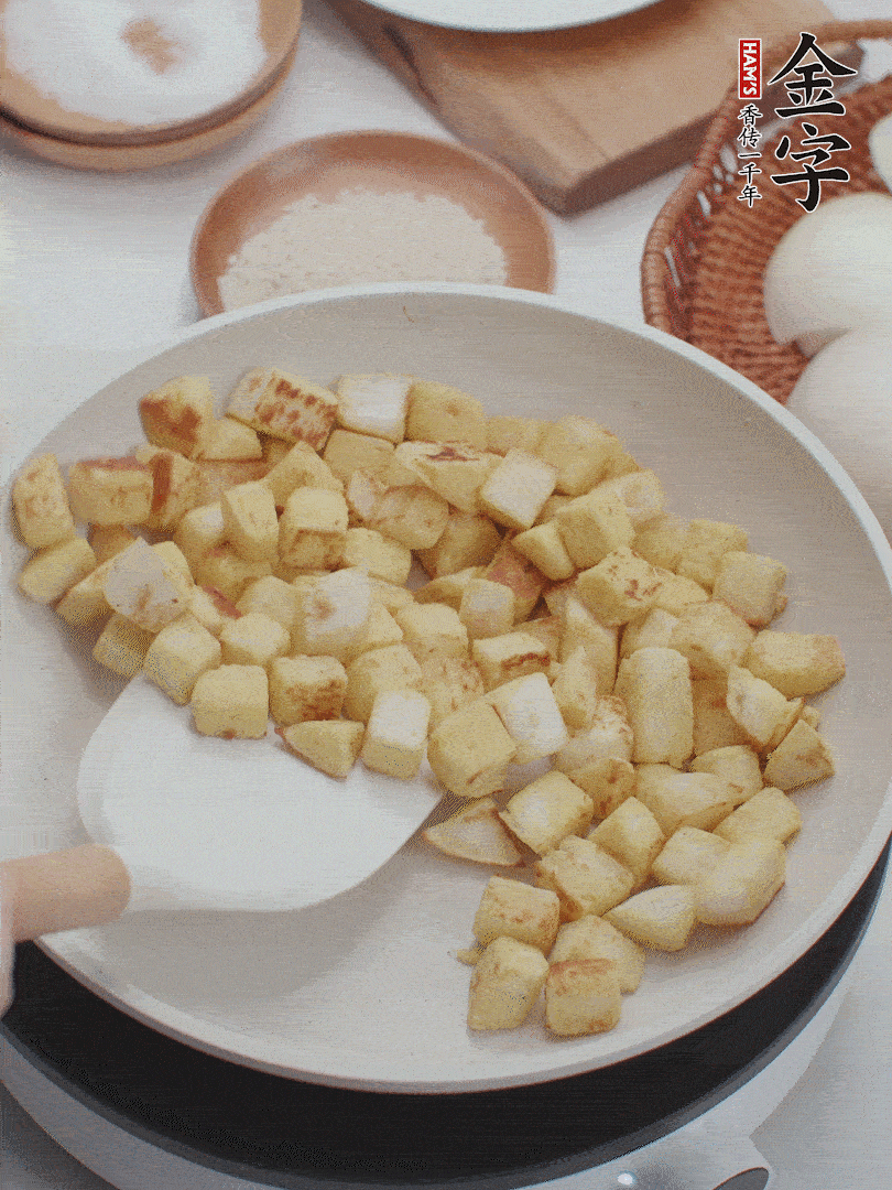 起鍋熱油，倒入饅頭丁，小火煎至蛋液凝固定型再翻面，饅頭丁部煎至金黃時盛起待用。