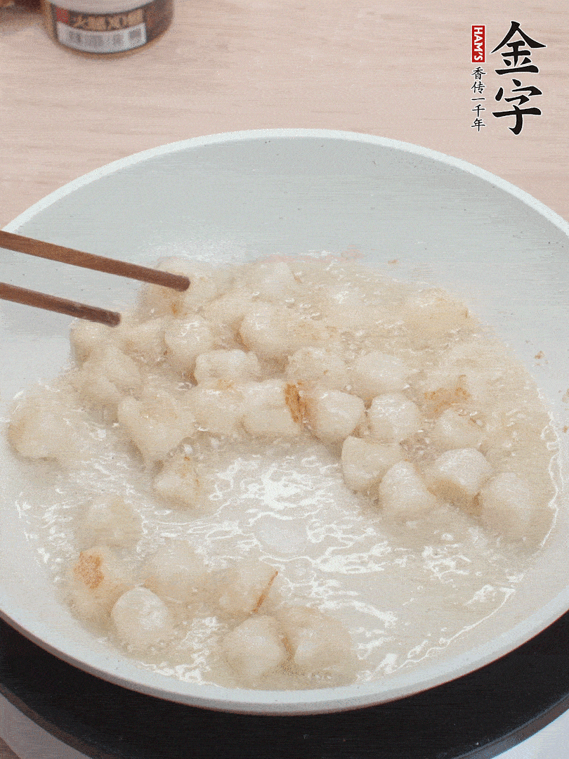 油溫4成熱，鮮貝蘸干淀粉下鍋煎，一面微黃后翻面。