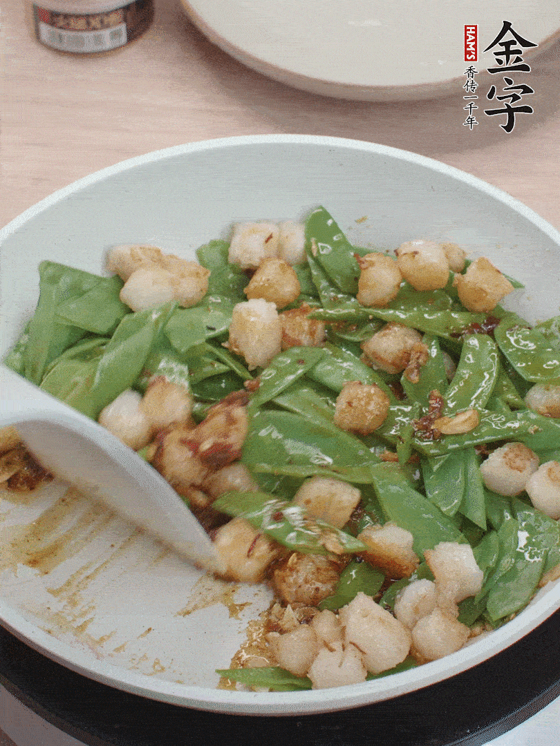 下甜豆莢、鮮貝輕輕翻炒均勻。