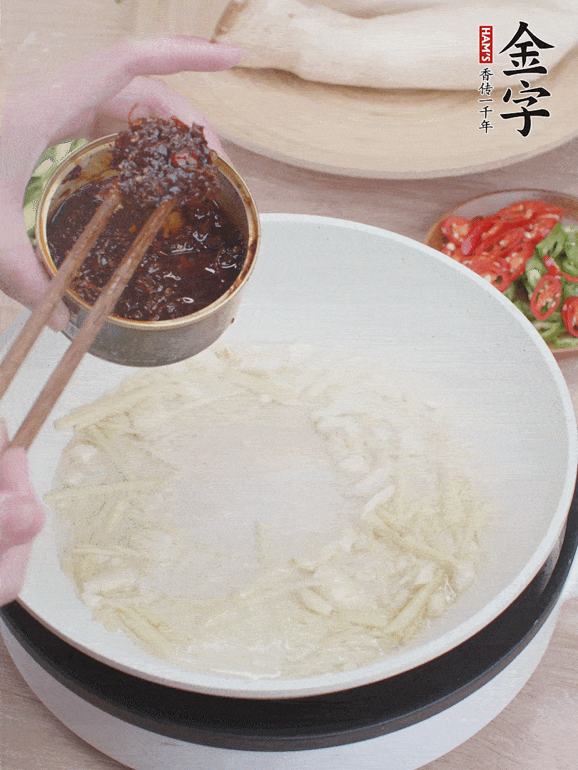起鍋熱油，姜蒜、金字火腿干貝醬煸香。