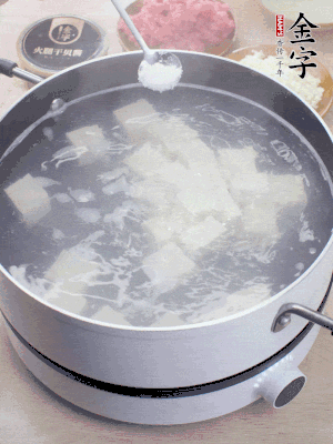 豆腐切成大小均勻正方體，鍋內(nèi)放水，加一點鹽焯水10秒。