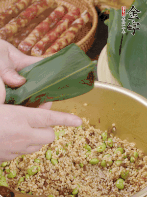 粽葉往下折，完全蓋住，兩側(cè)捏緊。