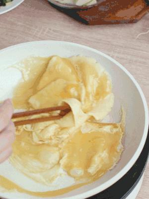 油6成熱時，下雞蛋液，邊緣凝固時翻拌成塊狀。