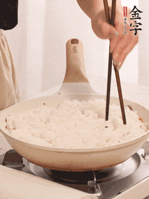 把瀝干水分的米飯均勻鋪在上面，筷子戳幾個(gè)洞，以便透氣，轉(zhuǎn)小火蓋上蓋子燜至水分收干，大概10分鐘。