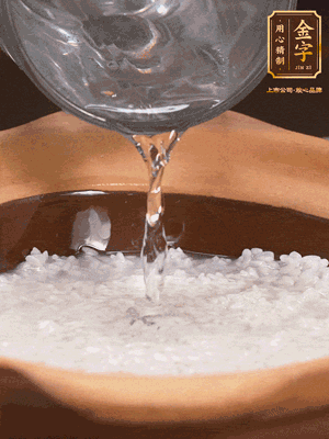 砂鍋底部刷一層油，加入大米和開水，水高1cm,大火燒開后轉(zhuǎn)中火煲5分鐘，到水微收干